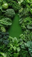 Fresh green vegetables assortment including broccoli lettuce and spinach arranged on green background gardening concept photo