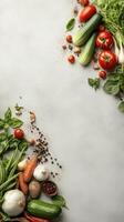 Fresh garden vegetables arranged on a gray surface. Tomatoes, cucumbers, beans, garlic, carrots, pepper, onions, zucchini and herbs. photo