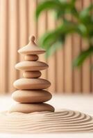 Stacked Stones Balanced on Sand with Raked Pattern and Green Plant against Wood Background, Symbolizing Calm and Peaceful Gardening photo