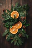 Citrus slices and evergreen branches arrange on a dark wooden surface with pine cones and leaf accents, creating a seasonal display. photo