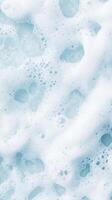 Close up of white bubbles. Light blue liquid with airy foam. Tiny air pockets in cleaning solution create soft surface texture. photo