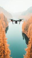 Drone flies over a serene lake. Tall trees line the shore. Mist fills the sky. The water reflects the forest photo
