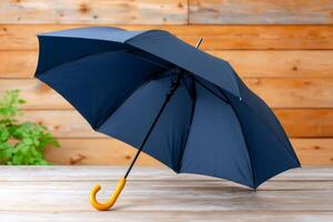 Classic blue umbrella resting on wooden table with yellow curved handle photo
