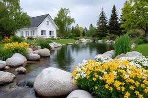 Beautiful white house with garden and pond reflecting cloudy sky photo