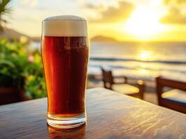 Sunset drinks by the beach with a refreshing amber beer photo