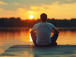 Person enjoys sunset view by calm lake on a warm evening photo