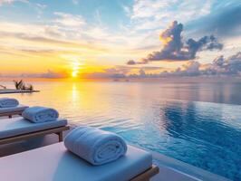 Serene sunset over tranquil ocean with lounge chairs by the pool photo