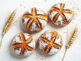 Freshly baked round bread rolls with wheat stalks on a table photo
