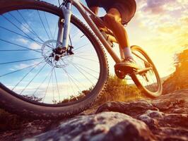 Biker navigating rocky terrain during sunset in outdoor adventure photo