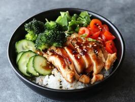 Delicious chicken rice bowl with fresh vegetables and sauce photo