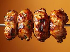 Grilled chicken skewers with herbs on a warm, orange background photo