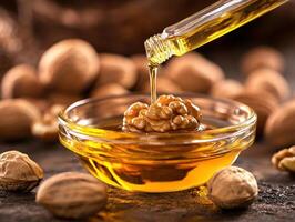 Walnut oil being poured over a walnut in a glass bowl photo
