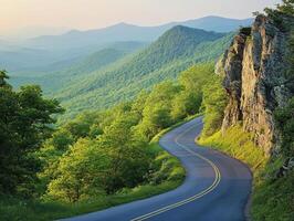 Winding road through lush green mountains during golden hour photo