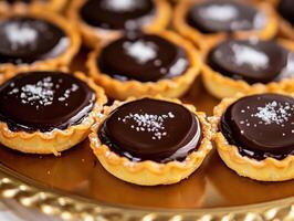 Chocolate tartlets on a decorative tray at a festive gathering photo