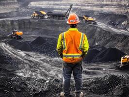 Worker observing coal mining operations at a quarry site photo