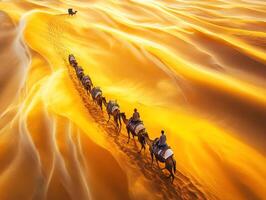 Camel caravan journeys across golden sand dunes in desert photo