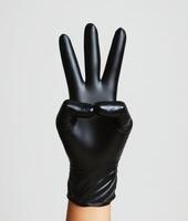Hand gesture showing three fingers with a black glove photo