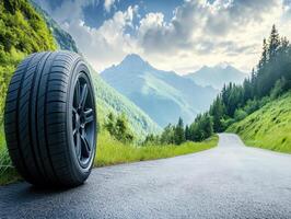 Scenic mountain road with a single tire on the roadside photo