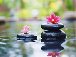 Relaxing spa scene with stones and flowers surrounded by water photo