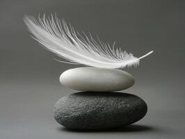 Feather resting delicately on stacked stones in serene arrangement photo