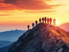 Hikers reach the summit at sunset in a mountain range photo