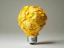 Creative light bulb made from yellow paper scraps in a studio setting photo