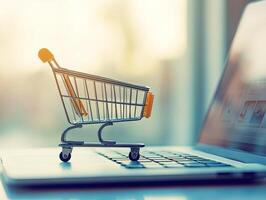 Online shopping concept with a miniature shopping cart on a laptop keyboard during a sunny afternoon photo