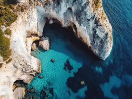 Breathtaking coastal view with clear water and rocky cliffs during sunny daylight photo