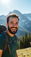 A man with a backpack smiles while standing in the mountains photo