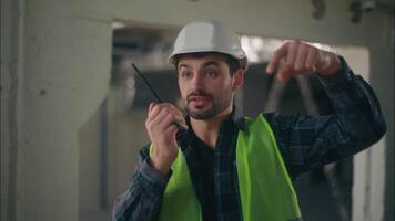 Caucasian guy foreman discussing walkie talkie in construction architect electrician man gesturing come here contractor male inspector explaining work handyman building builder manufacturing industry video