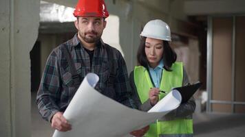 Multiethnic builders business inspection inspector check blueprint building afraid Caucasian man foreman hardhat showing project Asian woman industry construction write checklist control fail problems video