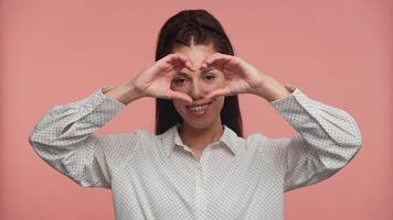 Smiling Woman Making Heart Shape with Hands on Pink video