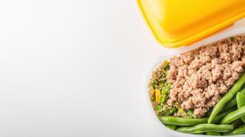 A healthy and delicious lunch packed in a reusable container features quinoa, green beans, peas and tuna for a nutritious and balanced meal preparation. photo