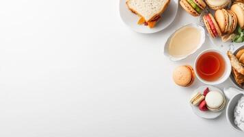 A delightful afternoon tea spread features assorted pastries macarons sandwiches and a cup of tea on a white background perfect for menu or blog design. photo