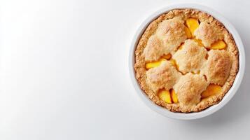 A delicious homemade peach pie baked in a white ceramic dish sits on a bright white background perfect for your summer recipe blog or cookbook. photo