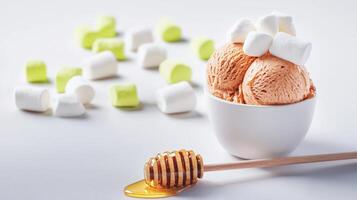 A delectable scoop of creamy caramel ice cream sits in a small white bowl topped with fluffy hmallows and a honey dipper rests nearby with golden honey dripping. photo