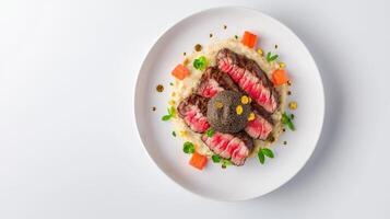 Gourmet sliced beef steak rests atop creamy risotto garnished with truffle sauce and vibrant orange accents on a pristine white plate against a bright background. photo