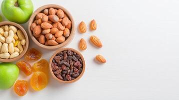 Healthy snack assortment featu dried apricots, raisins, almonds, cashews and green s arranged on a bright white background in wooden bowls for a nutritious and delicious photo