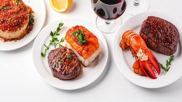 A delectable gourmet meal featu pan-seared scallops, grilled fillet mignon steaks, and succulent lobster tail served with red wine for a luxurious dining experience. photo