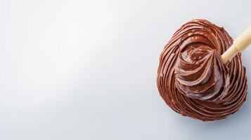 Chocolate frosting with wooden spoon on white background photo