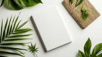 White notebook with green leaves and leaves on white background photo