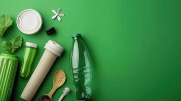 Plastic bottles, plastic utensils and other items on a green background photo