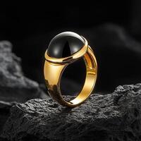 A gold ring with black onyx stone on top photo
