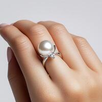 A woman's hand holding a pearl ring photo