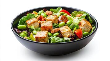 A bowl of salad with tofu, vegetables and almonds photo