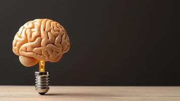 A brain shaped light bulb is sitting on top of a wooden table photo