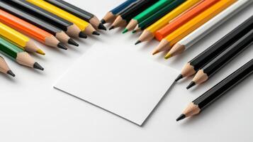 A group of colored pencils and a blank piece of paper photo