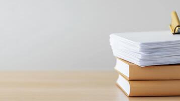 Stack of books and pen on wooden table photo