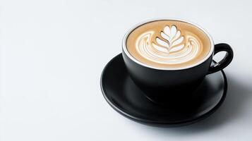 A black cup of coffee with a leaf pattern on top photo