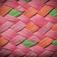 A close up of a woven basket with pink, green and orange colors photo